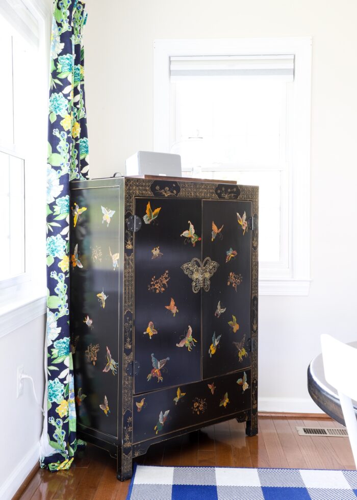 A black Butterfly Cabinet in the corner of a dining room