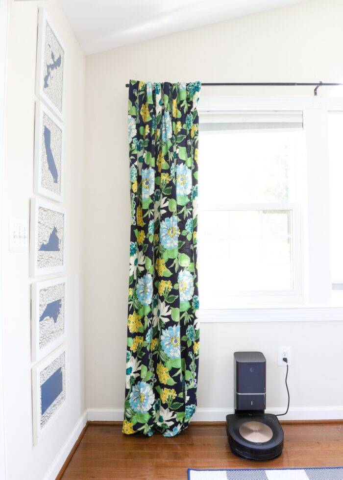 Navy, turquoise, yellow and green floral drape hung on a black rod