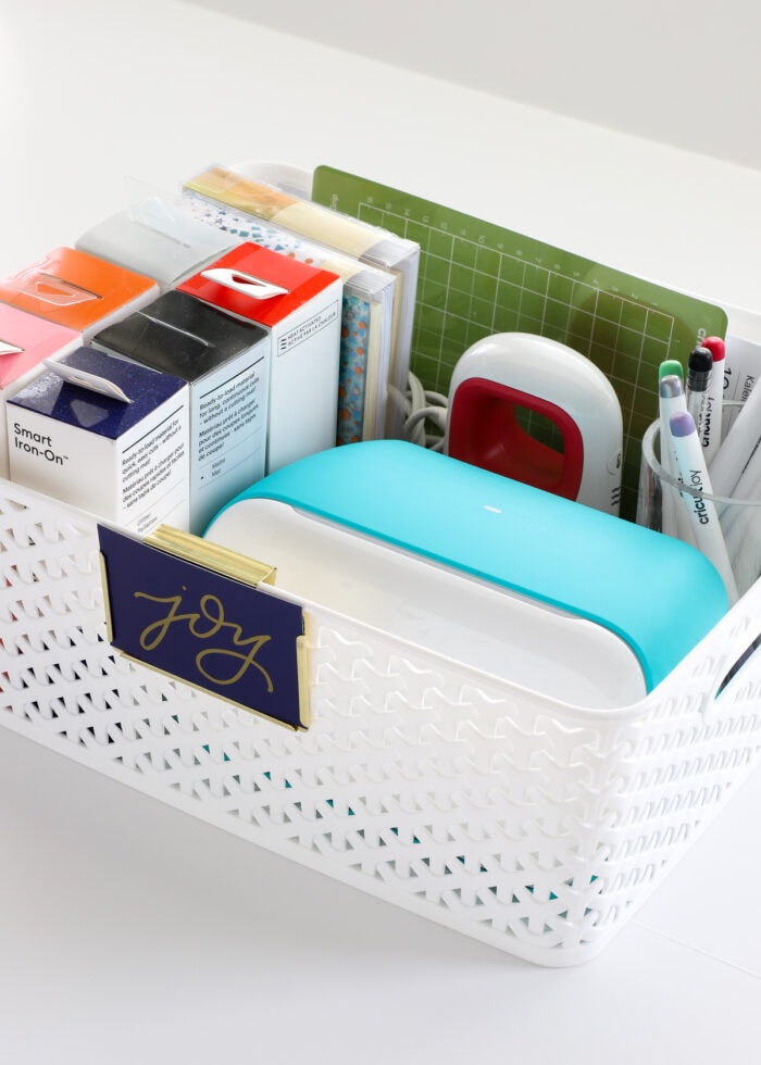 Cricut Joy machine inside a white basket with supplies