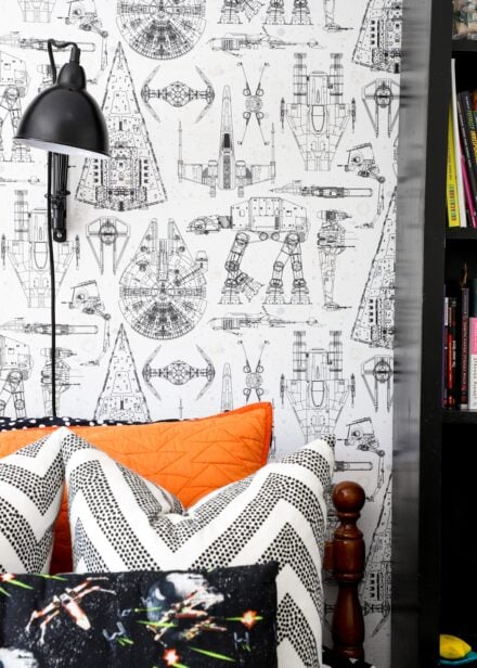 Star Wars wallpaper behind a wooden twin bed