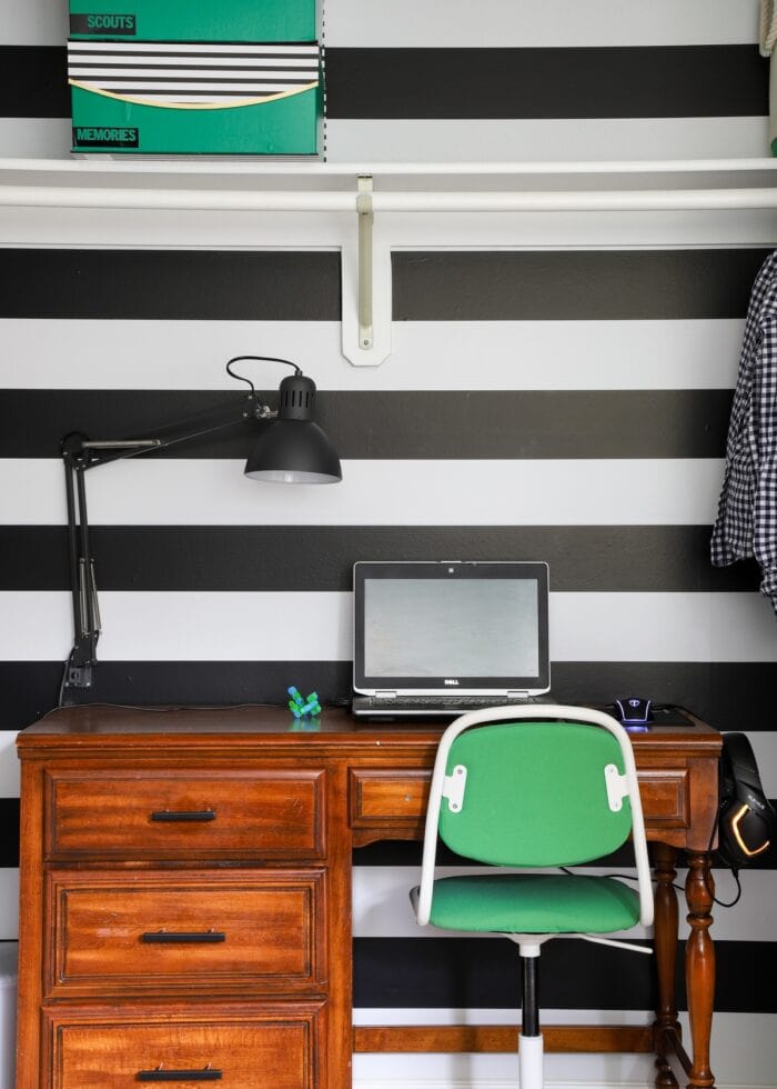 Closet with black-and-white wallpaper and a wooden desk