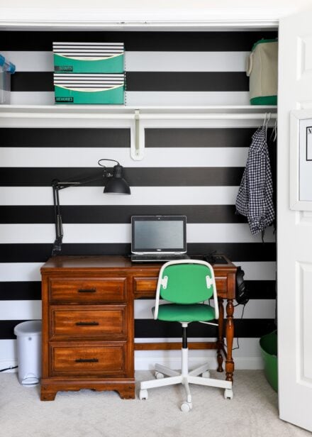 Closet with desk inside against black-and-white striped wallpaper