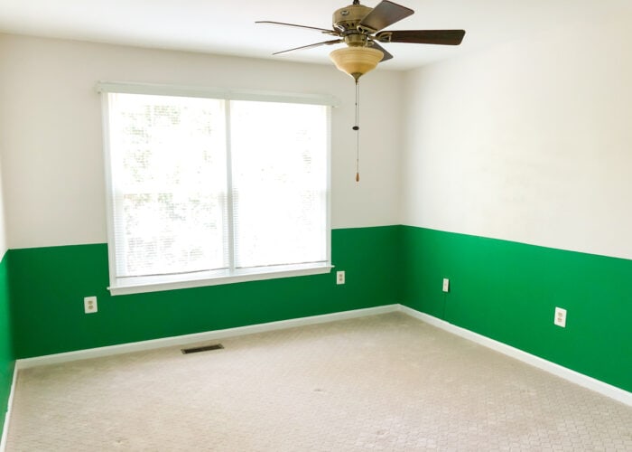 Empty room with green half wall and beige carpet