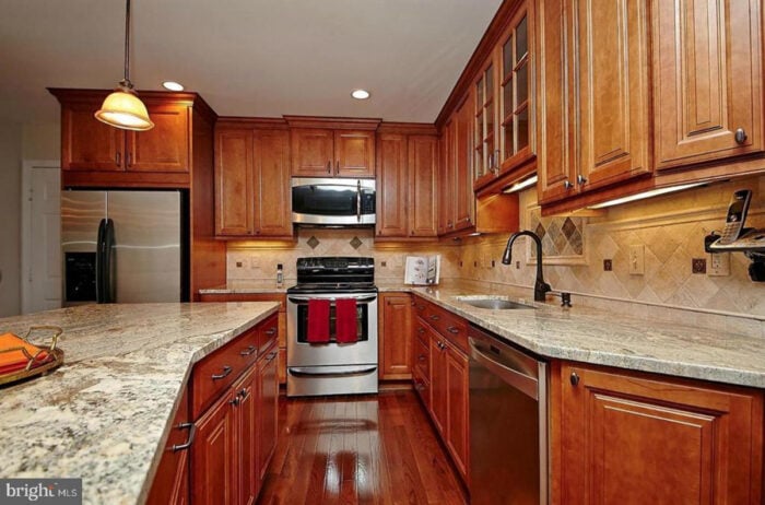Rental kitchen with wood cabinets and rustic tile backsplash