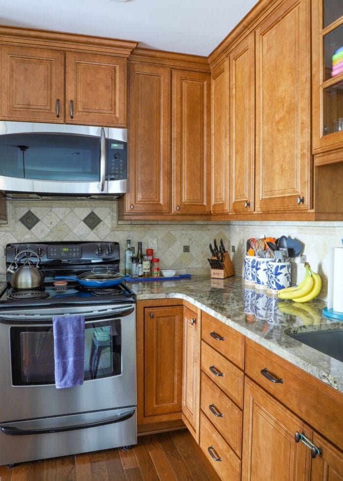 Kitchen with oak cabinets, rustic backsplash, and granite countertops
