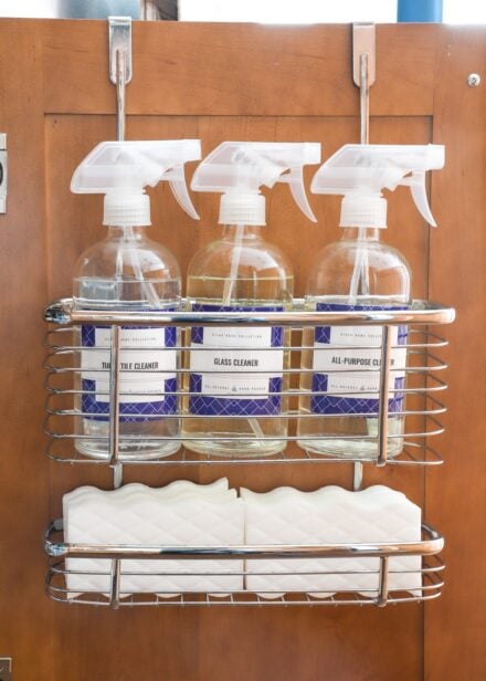 Organizer on back of kitchen cabinet door holding cleaning supplies