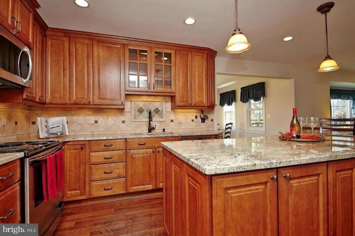 Rental kitchen with wood cabinets and rustic tile backsplash