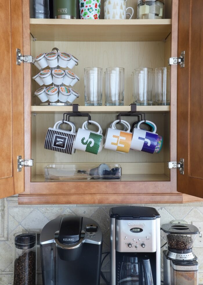 Coffee mugs and glasses organized in an upper kitchen cabinet