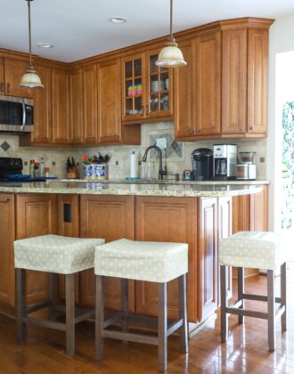 Rental kitchen with custom wood cabinets and covered bar stools