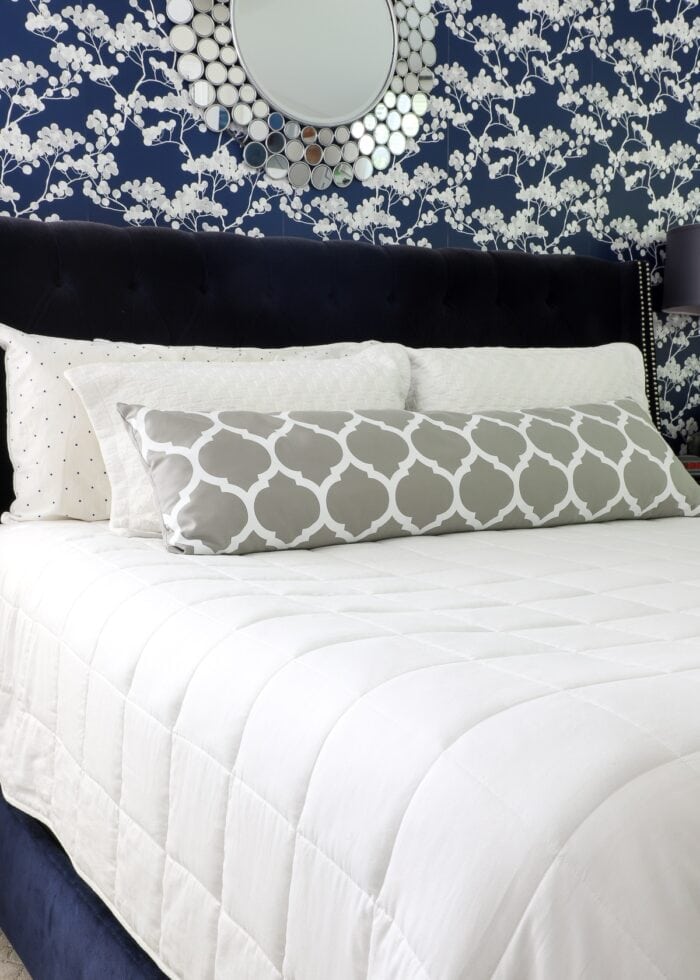 Navy and white bedroom with a white weighted blanket on the bed