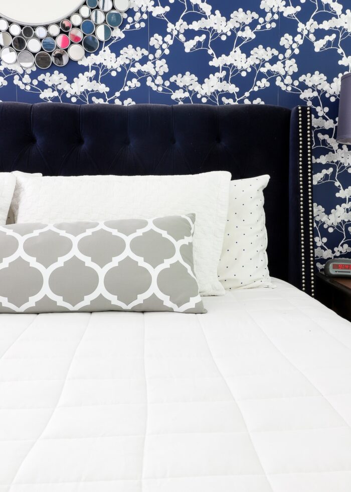 Navy and white bedroom with a white weighted blanket on the bed