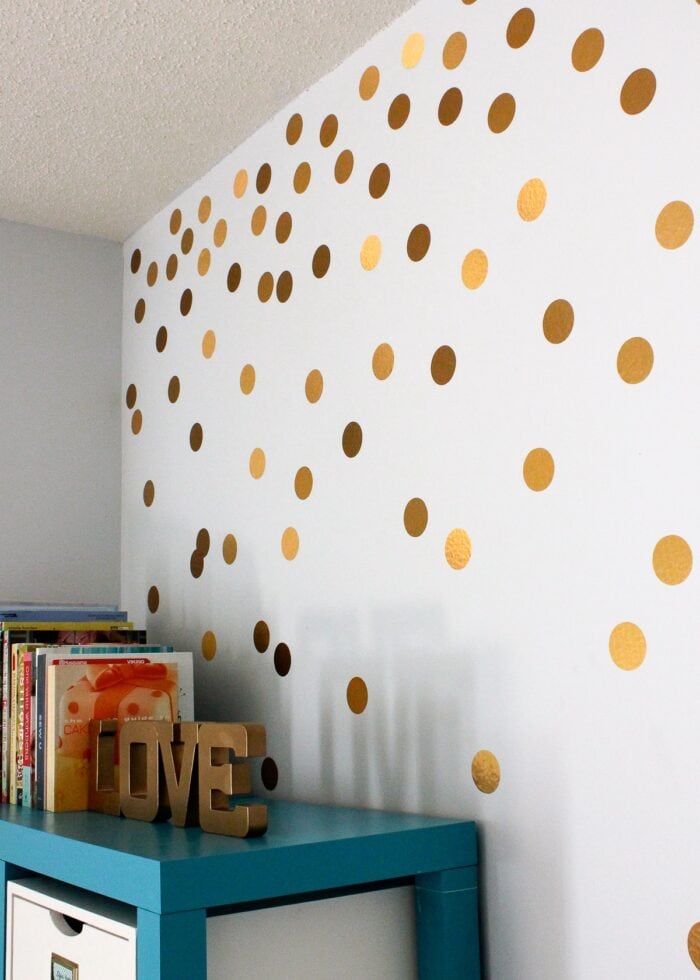 Gold polka dot stickers on a light blue wall