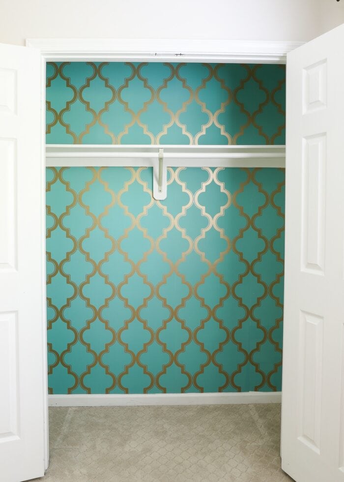 Closet with turquoise wallpaper along the back
