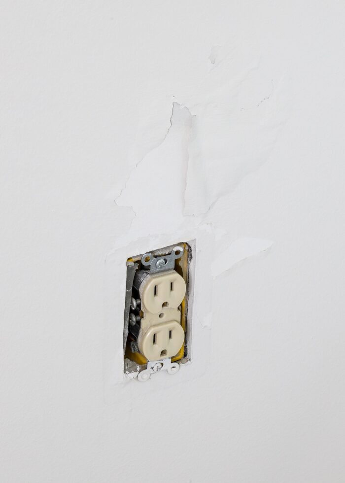 Dry wall pulled up around outlet from removing peel and stick wallpaper