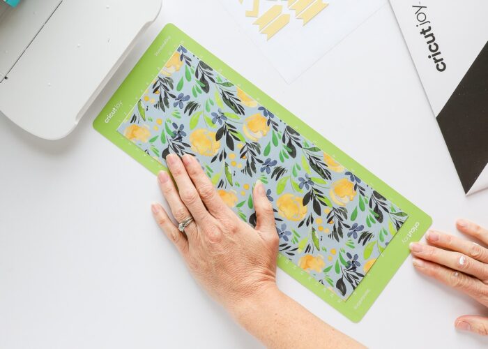 Hand loading Adhesive-Backed Deluxe Paper on Cricut Joy mat