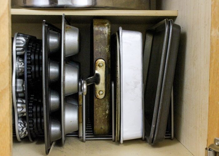 Pans in vertical organizers inside a cabinet