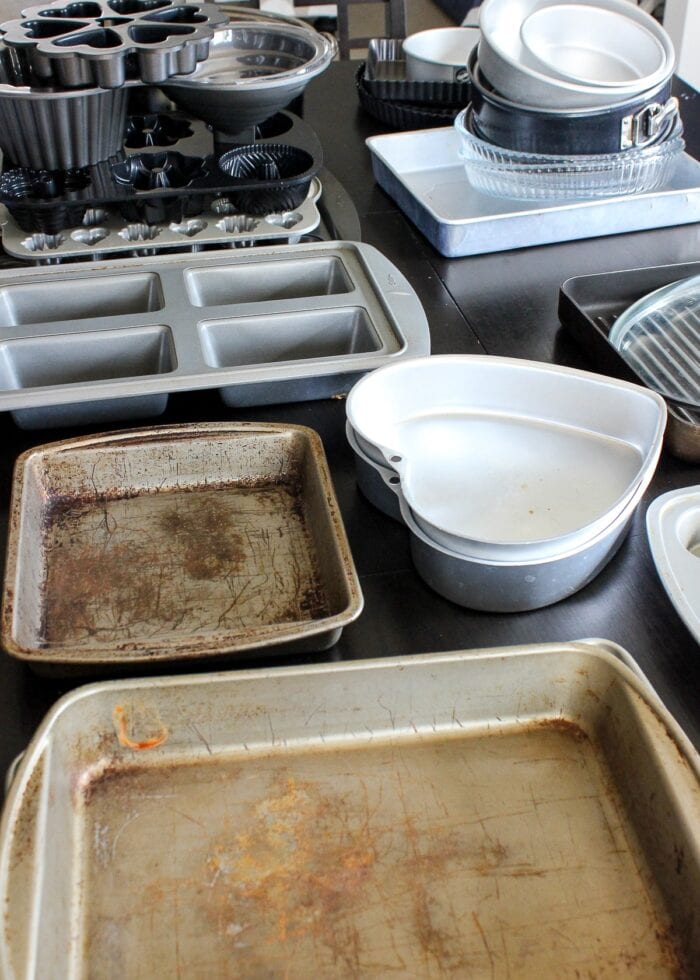 Lots of baking pans spread out on a table