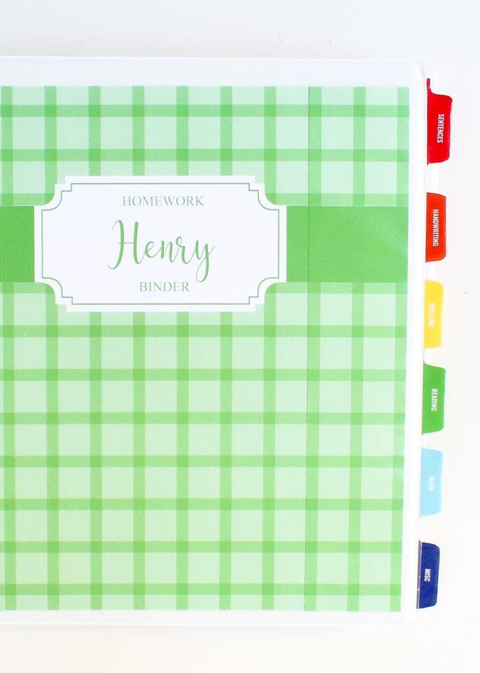 A white binder with a green printable binder cover and colorful tabs down the side