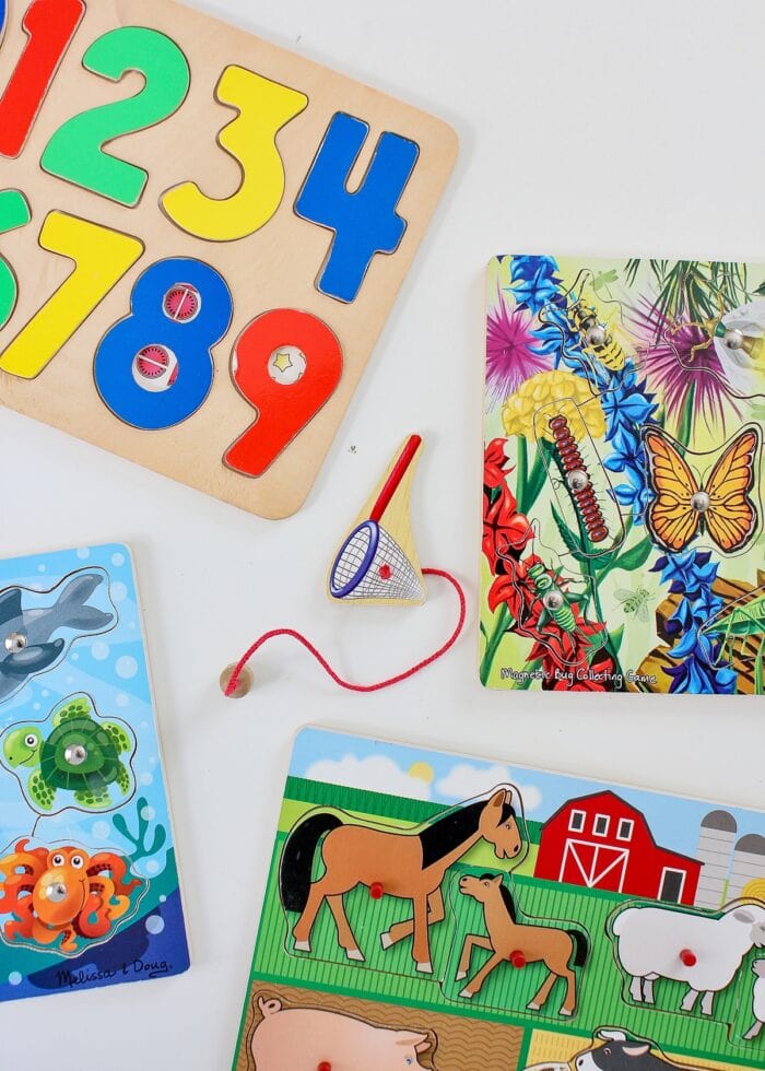 A collection of wooden kid puzzles on a white table