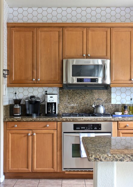 Kitchen with oak cabinets and a white wallpaper backsplash