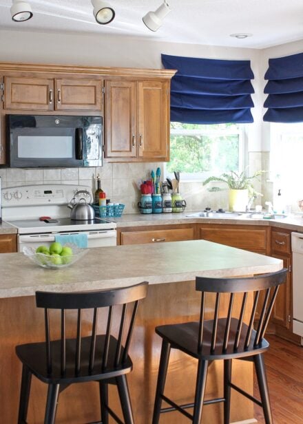 Kitchen with oak cabinets and navy window shades