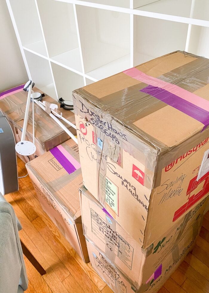 Stacks of moving boxes with pink and purple lengths of tape