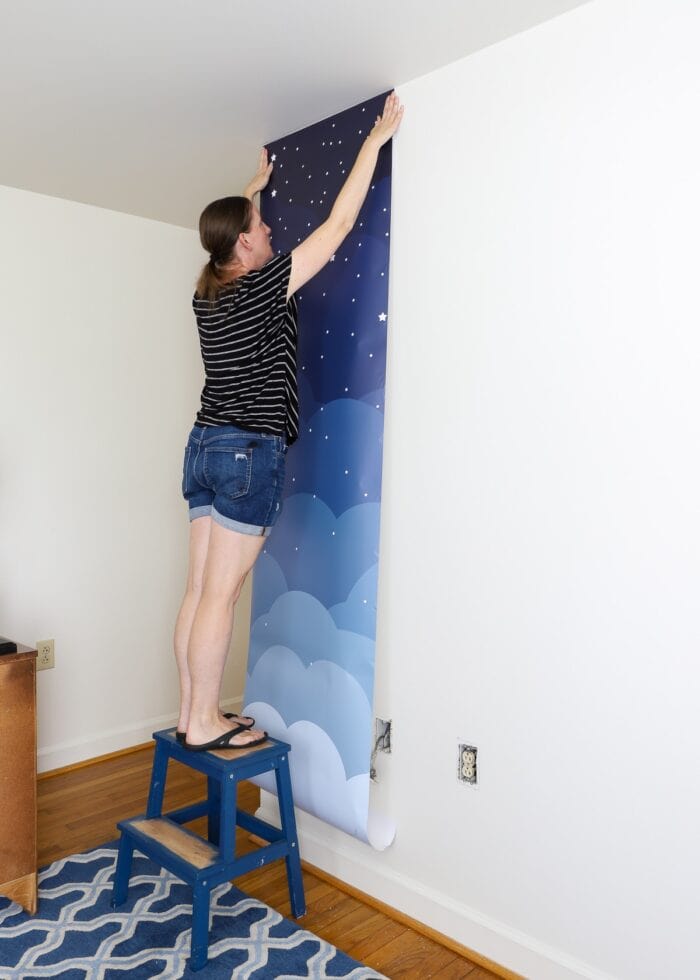 Megan hanging first wallpaper mural panel