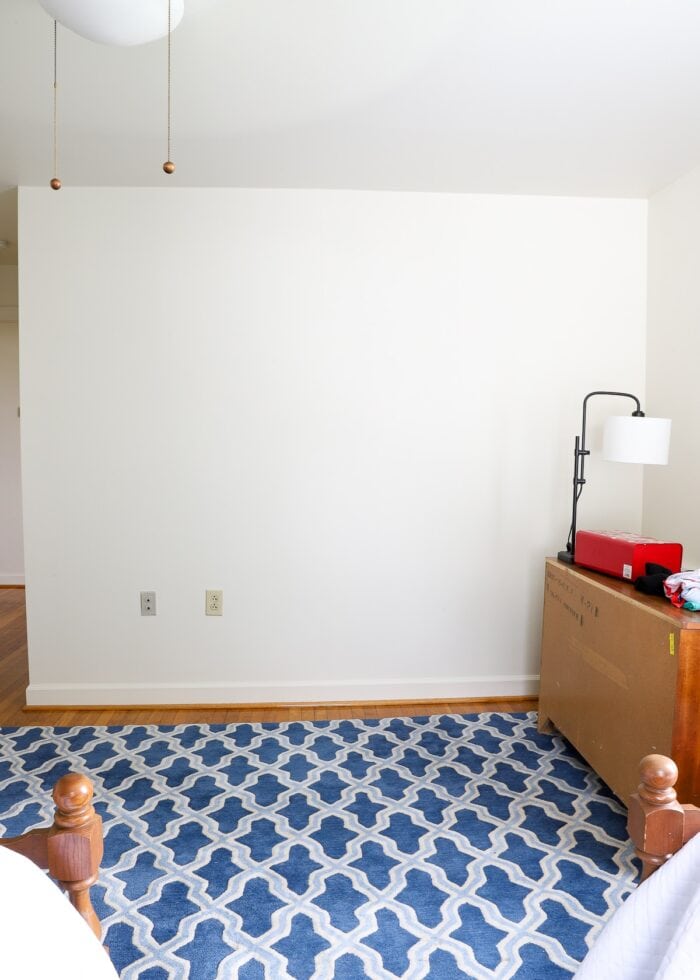 White wall of bedroom with blue carpet