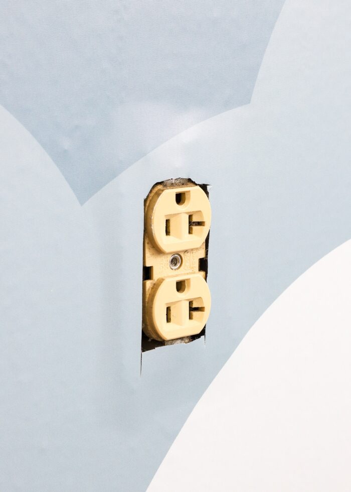 Wall outlet surrounded by wallpaper mural panel