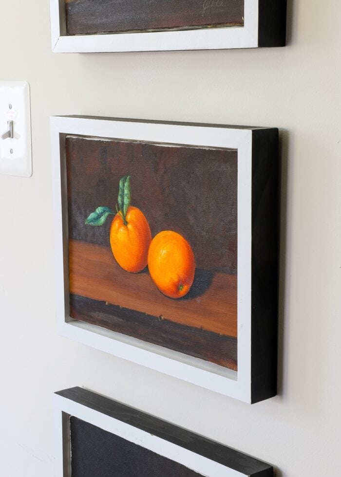 Painting of oranges held up with Command Strips