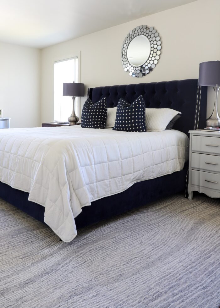 Grey swirl wool rug with navy bed