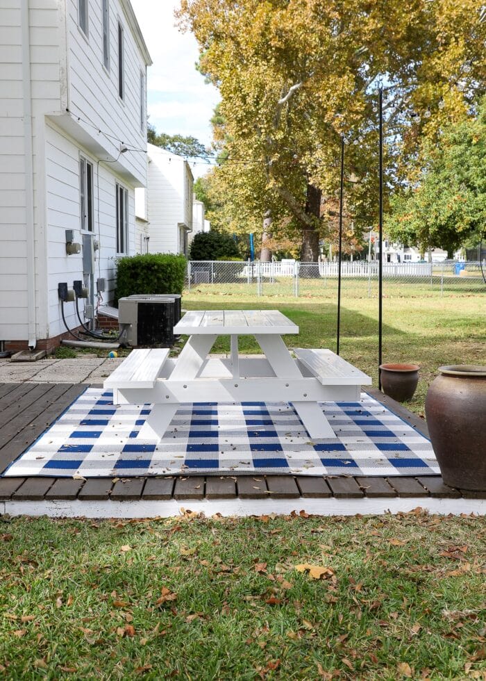 Buffalo Plaid Outdoor Rug (8x10') from Target under a white picnic table