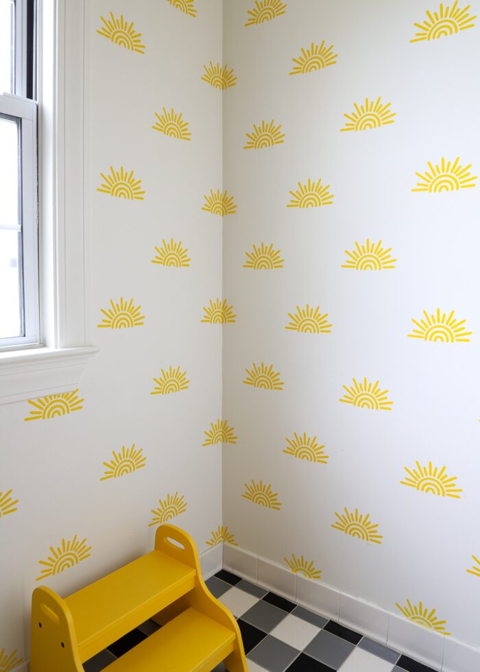 Yellow sunshines stenciled on a bathroom wall