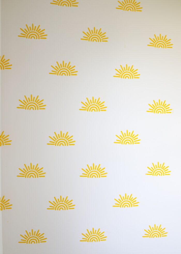 Yellow sunshines stenciled on a bathroom wall