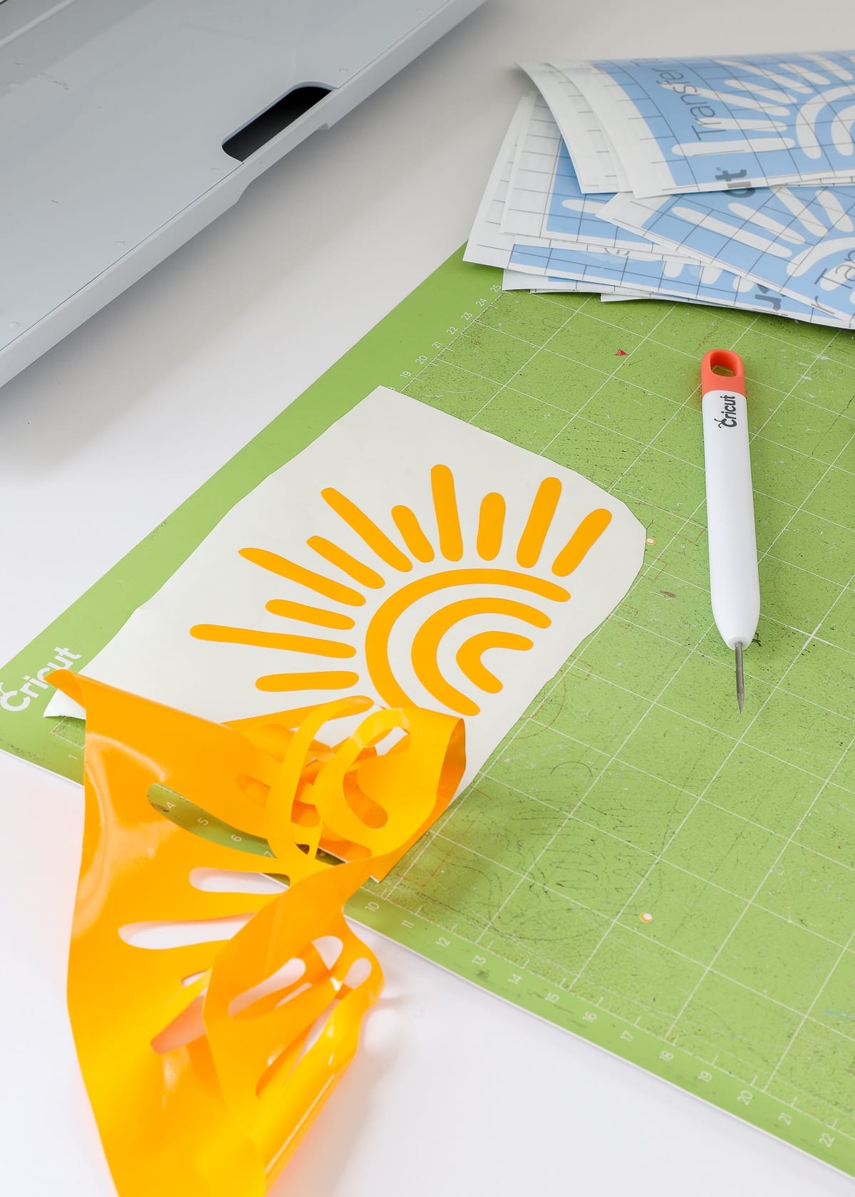 Sunshine decal cut from yellow vinyl shown on a cutting mat