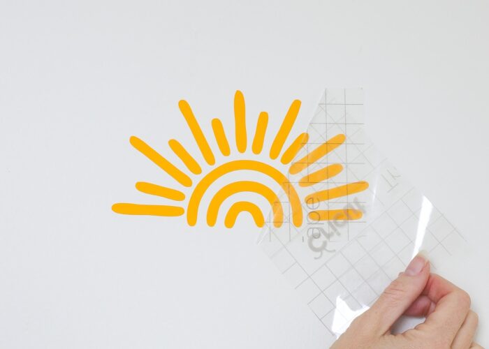 hand pulling away transfer tape of sunshine decal