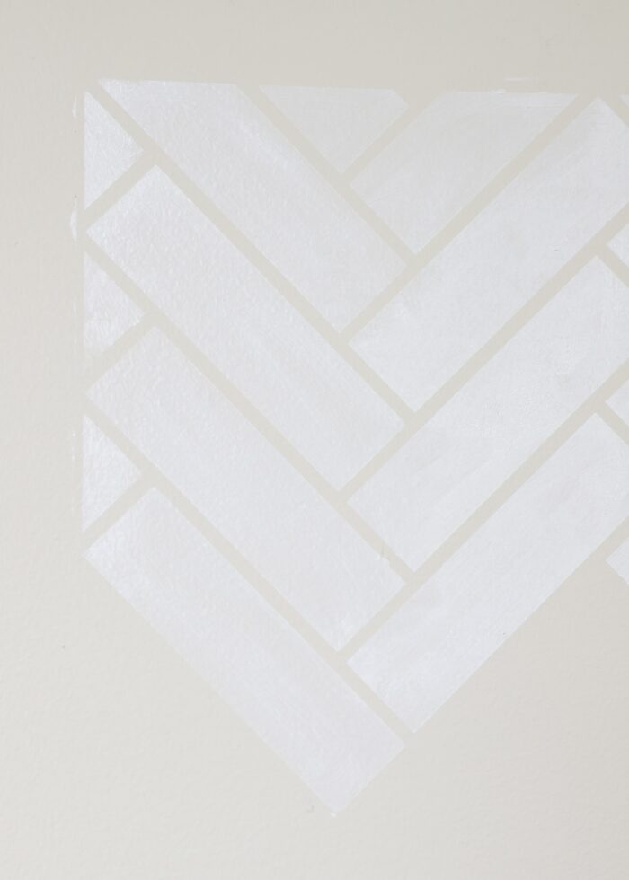 Herringbone tile pattern stenciled on tan wall