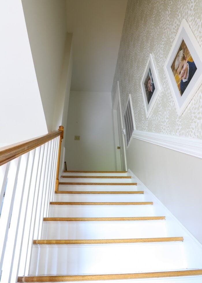 View heading up a staircase with wallpaper on the wall
