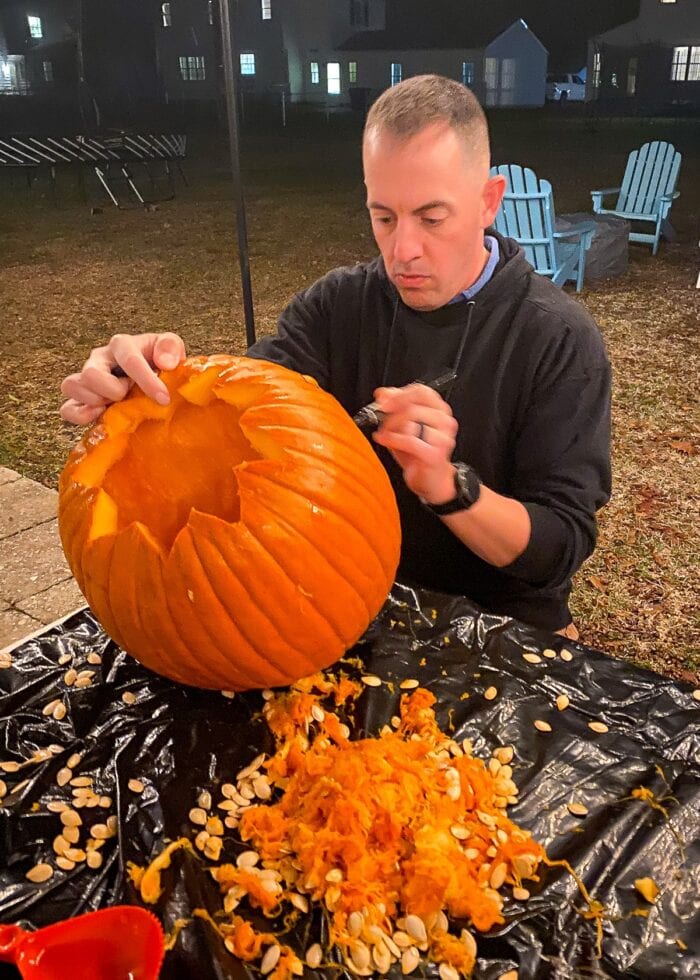 Greg carving pumpkin