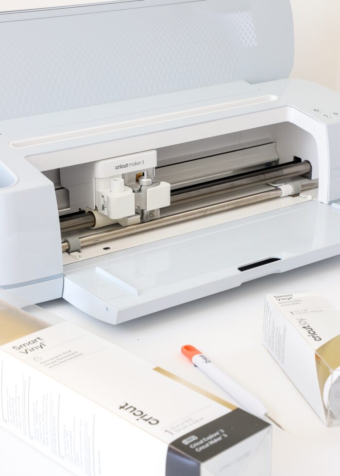 Cricut Maker 3 shown with two rolls of gold Smart Vinyl
