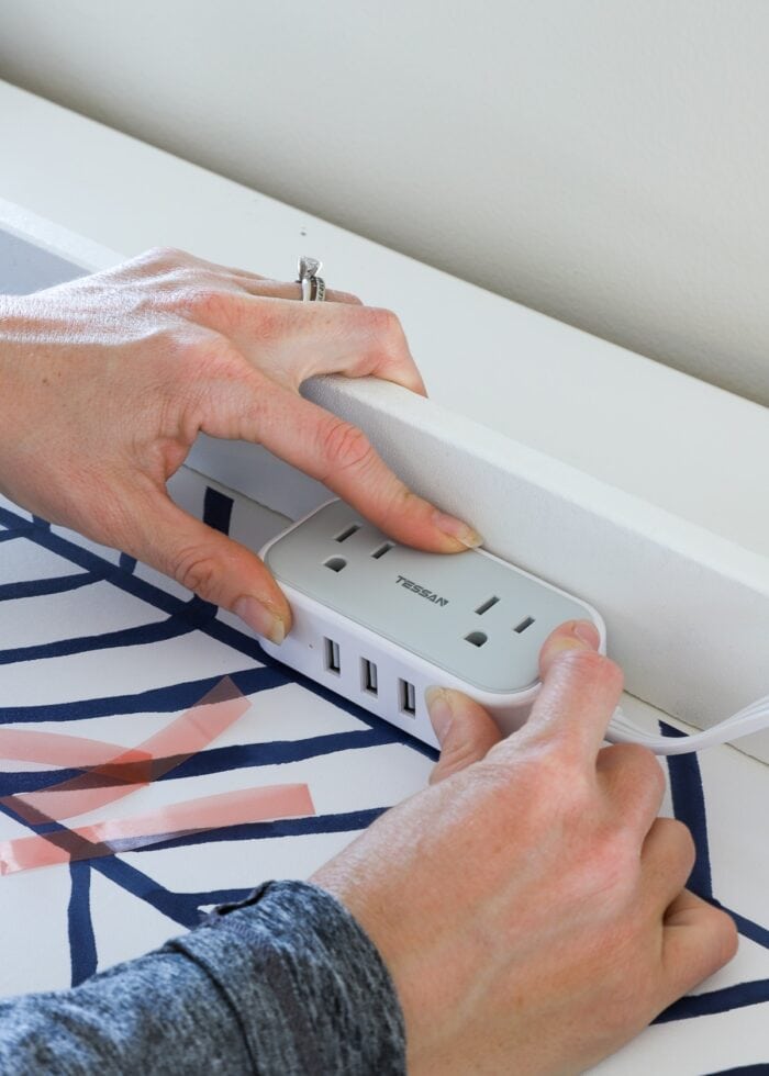 Hands placing usb and charging port inside drawer