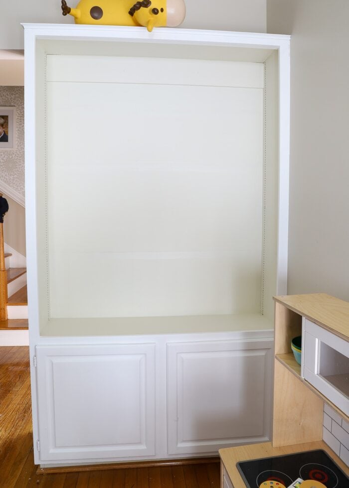 Built-in bookcase with white frame and beige backing
