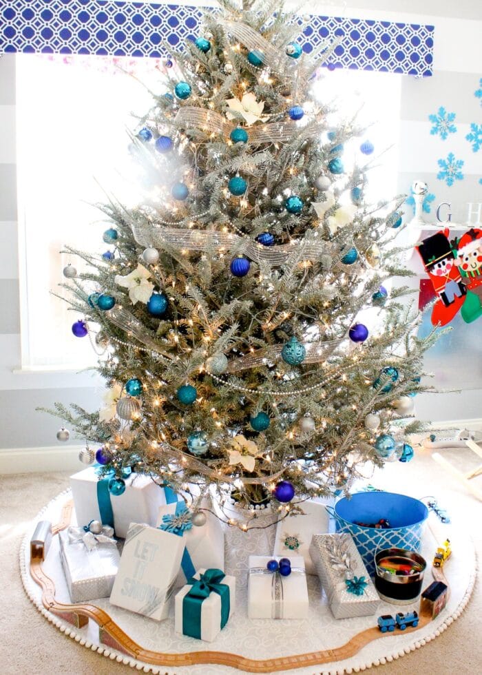 Large white Christmas tree skirt under an flocked tree with blue ornaments