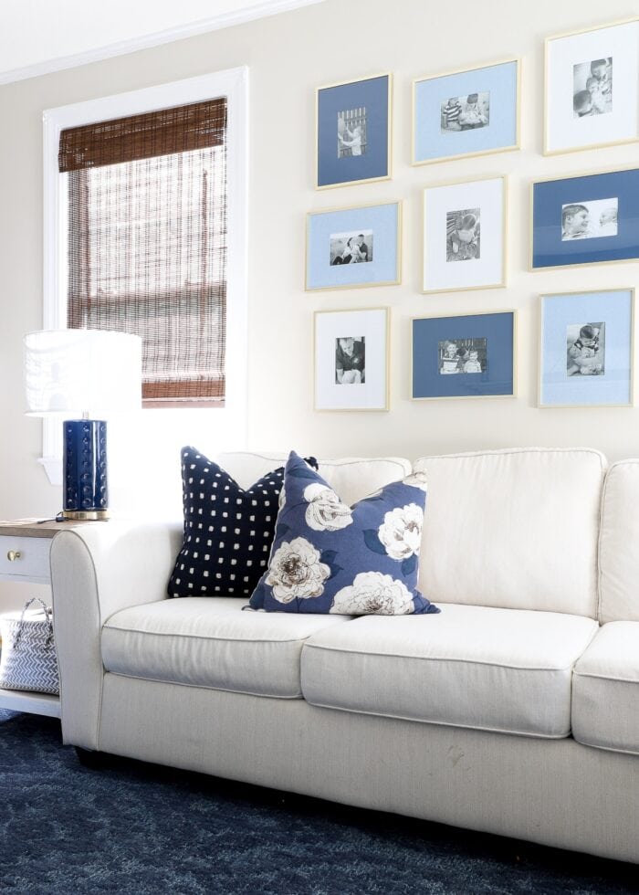 Family room with white couch and blue rug with blue frames on the wall