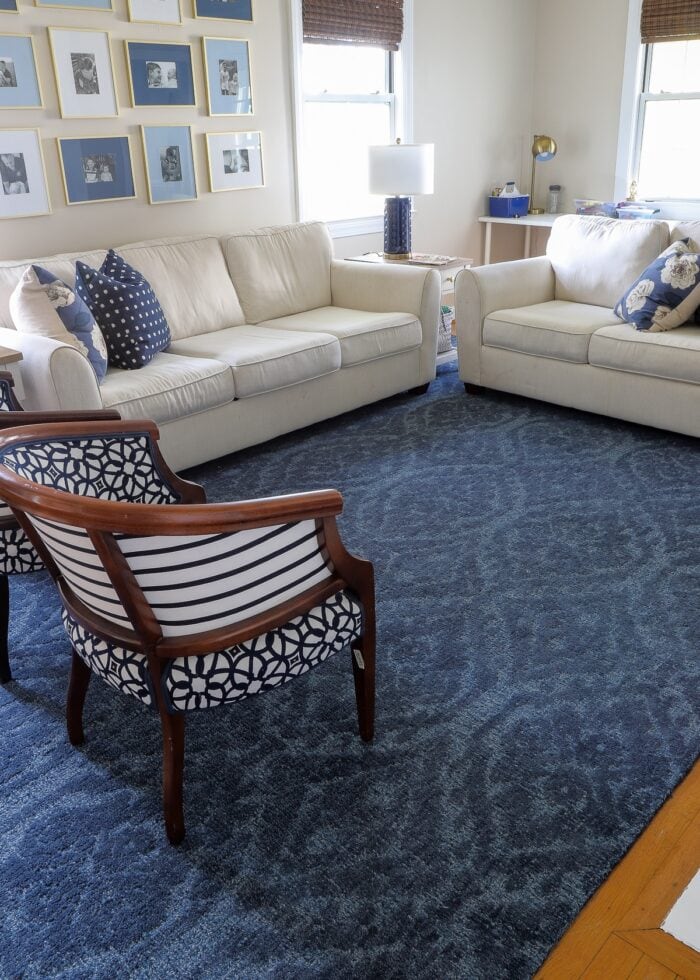 Blue rug underneath white couches