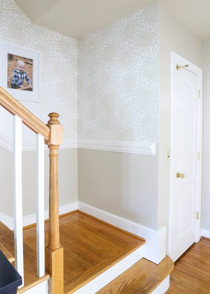 Stairwell with wallpaper on the wall and pine stairs