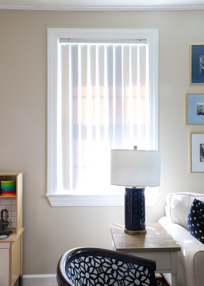 Vertical blinds on a window surrounded by white trim