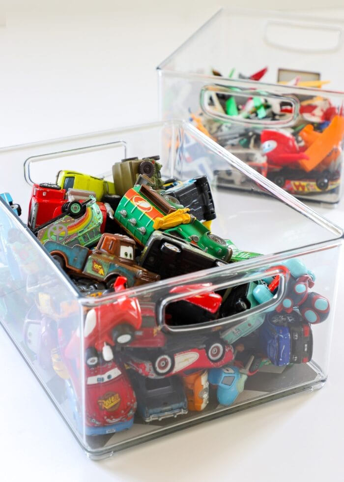 Clear acrylic bins holding toy cars and planes