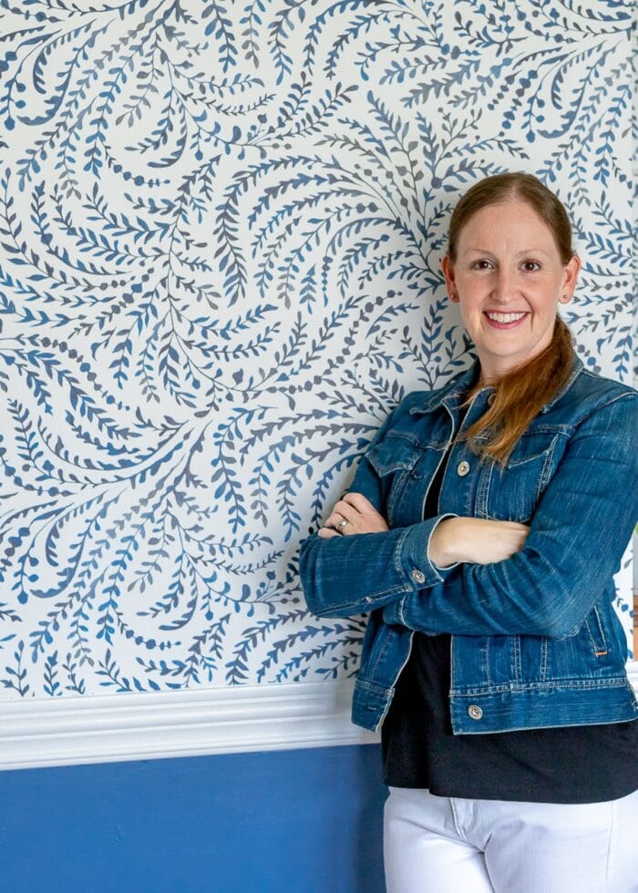 Megan in front of wallpapered wall