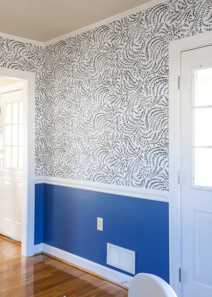 Blue and white wallpaper on the wall above white chair rail